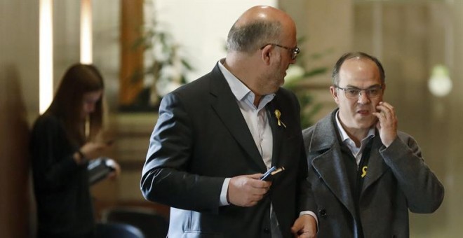 El diputado de Junts per Catalunya, Jordi Turull (i), junto al portavoz parlamentario del grupo, Eduard Pujol (d), en los pasillos del Parlament. /EFE
