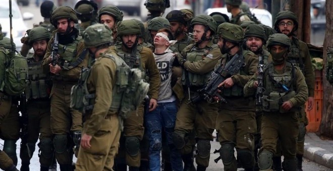Soldados israelíes detienen a un joven palestino durante unas protestas contra la decisión del presidente estadounidense, Donald Trump, de reconocer a Jerusalén como capital de Israel, en la ciudad cisjordana de Hebrón (Palestina). Abed Al Hashlamoun (EFE