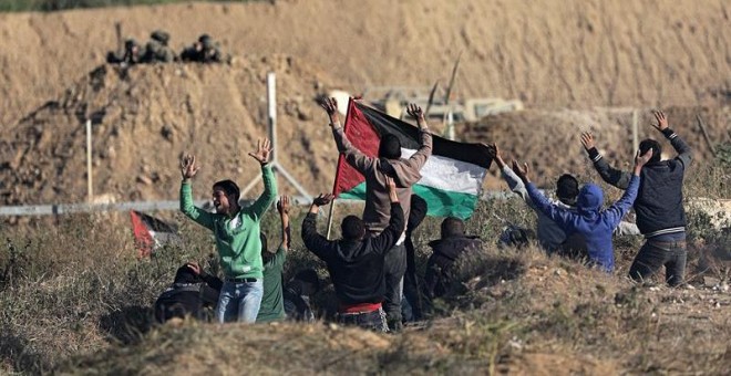 Manifestantes palestinos saludan a los soldados israelíes durante los enfrentamientos con las tropas israelíes a lo largo de la frontera entre Israel y la Franja de Gaza.  EFE / EPA / MOHAMMED SABER