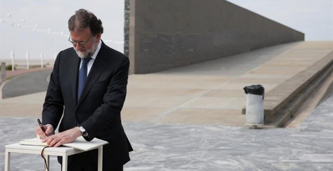 El presidente del Gobierno, Mariano Rajoy, firma en el libro de honor a las victimas de la dictadura argentina durante su visita al Parque de la Memoria. / EFE