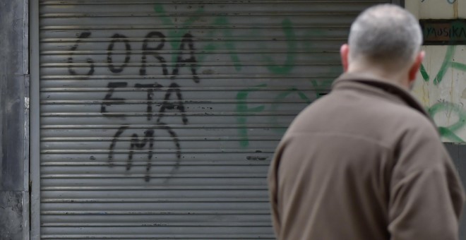 Un hombre pasa junto a una pintada en apoyo a ETA en la la localidad guipuzcoana de Hernani. AFP/Ander Gillenea