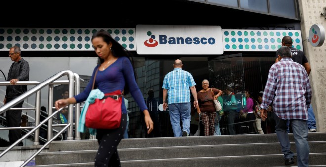 Varias personas llegan a una sucursal del banco Banesco  en Caracas,. REUTERS/Carlos Garcia Rawlins