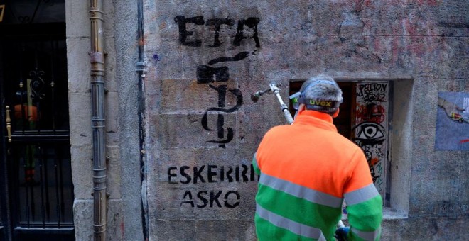 Un emlpeado municipal limpia en Bilbao una pintada que dice, en vasco, 'ETA gracias', dos días después del anuncio de disolución de la organización terrorista. REUTERS/Vincent West