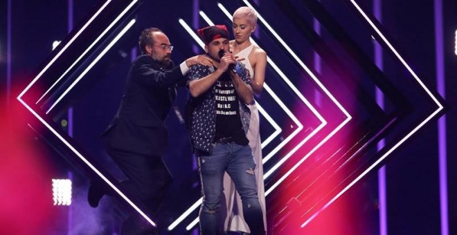 Momento en el que el espontáneo arrebata el micrófono a SuRie en plena actuación en Eurovisión. /EFE