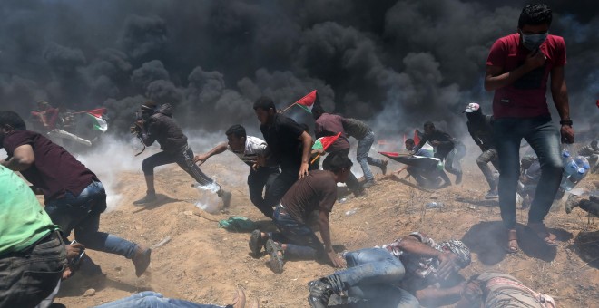 Un grupo de palestinos huyen y se tiran al suelo ante el fuego israelí en Gaza. /REUTERS