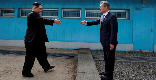 El presidente de Corea del Sur, Moon Jae-in, al estrechar la mano al líder norcoreano, Kim Jong Un, en la frontera entre ambos países el pasado 27 de abril. /REUTERS