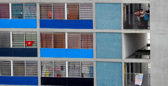 Varias personas observan desde su vivienda el mitin de cierre de la campaña electoral de Nicolás Maduro, para las presidenciales de Venezuela. REUTERS/Adriana Loureiro