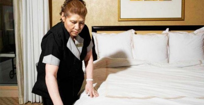 Imagen de una camarera de piso haciendo una cama en un hotel.- EFE