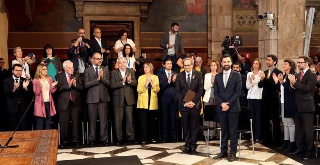 El presidente de la Generalitat, Quim Torra (i), y el del Parlament de Cataluña, Roger Torrent (d), reciben el aplauso de los nuevos consellers del gobierno catalán a su llegada al acto de toma de posesion del nuevo Govern que se celebra hoy en el Palau d