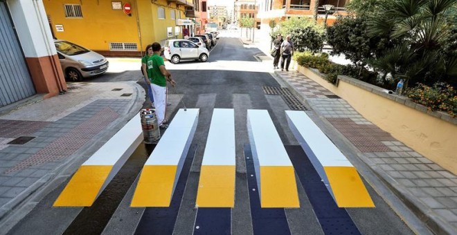 Un operario trabaja en la colocación del primer paso de peatones en 3D termofusible de España, en Almussafes, Valencia. / EFE