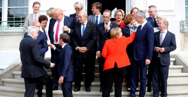 La canciller alemana Angela Merkel y el presidente francés Emmanuel Macron, con sus ministros, antes para posar para la foto de familia de la cumbre franco-germana, en el Palacio de Meseberg. REUTERS/Hannibal Hanschke