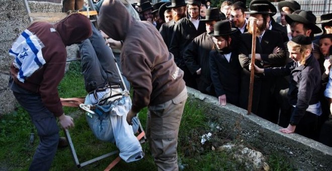 Un grupo de activistas de derecha israelíes organizan una protesta que representa lo que dicen son los métodos utilizados por la inteligencia israelí servicios para interrogar a los sospechosos extremistas judíos. MENAHEM KAHANA / AFP