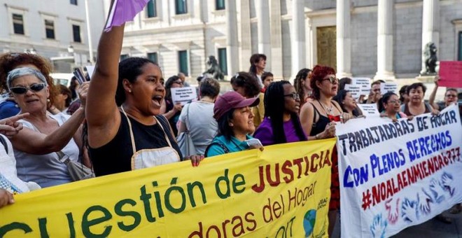 Trabajadoras del hogar y cuidados durante la concentración convocada esta tarde frente al Congreso de los Diputados de Madrid para denunciar la enmienda introducida en los presupuestos generales del Estado que retrasa en cinco años la equiparación de las