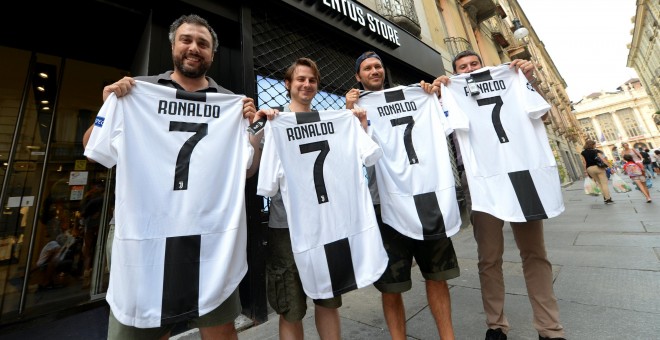 Varios hinchas de la Juventus posan con la camiseta del equipo con el nombre y el número de Ronaldo tras confirmarse su traspaso. /REUTERS