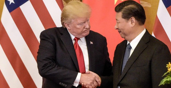 Donald Trump, a la izquierda, estrechando la mano del líder chino, Xi Jinping - FRED DUFOUR/AFP