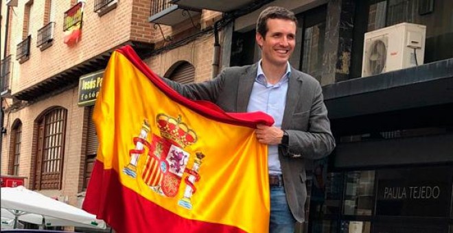 Pablo Casado posando con la bandera de España, subido a un coche. /TWITTER DE PABLO CASADO