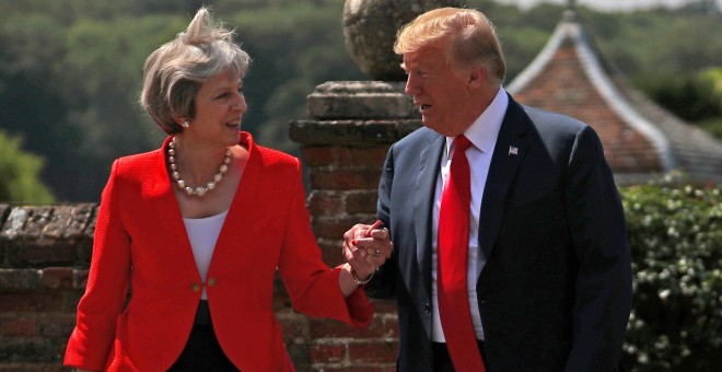 Donald Trump y Theresa May se saludan antes de su encuentro en la residencia de Chequers. /REUTERS