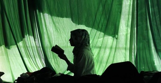 La silueta de una mujer leyendo un libro en Indonesia./REUTERS