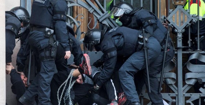 23 de febrero de 2018.- Los mossos cargan contra un centenar de personas encadenadas al TSJCat. EFE/Quique García
