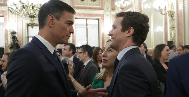 El presidente del Gobierno, Pedro Sánchez, conversa con el líder del PP, Pablo Casado, en presencia de la presidenta del Congreso, Ana Pastor, en el Salón de los Pasos Perdidos poco antes de la presentación de los actos conmemorativos del cuarenta anivers