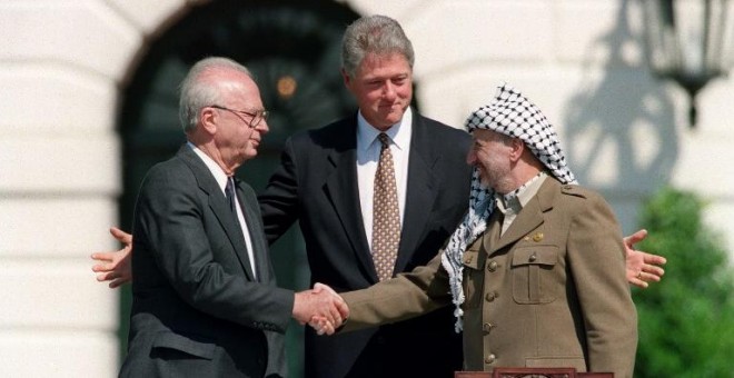 El primer ministro israelí, Isaac Rabin, y el líder de la OLP, Yasser Arafat, se estrechan la mano en presencia del presidente de EEUU, Bill Clinton, en los jardines de la Casa Blanca, en Washington, para sellar los Acuerdos de Oslo, el 13 de septiembre d