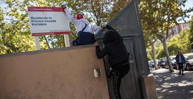 Dos menores migrantes saltan el muro para acceder al Centro de Primera Acogida de Menores de Hortaleza, en Madrid.- JAIRO VARGAS