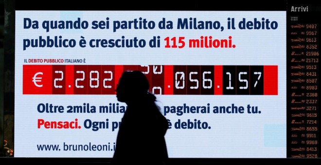 Una mujer pasa frente al llamado 'reloj de la deuda, instalado en la Estación Términi, de Roma, por el Instituto Bruno Leoni, que muestra el crecimiento de la deuda pública de Italia. REUTERS / Alessandro Bianchi