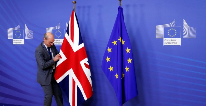 Un empleado de la Comisión Europea coloca la bandera británica.- REUTERS