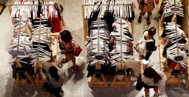 Un grupo de mujeres echan un vistazo a varios conjuntos de ropa en una tienda de un centro comercial de Sidney. REUTERS/Daniel Munoz