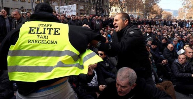 Dos taxistas se encaran durante la asamblea que han celebrado este sábado en Barcelona. (TONI ALBIR | EFE)