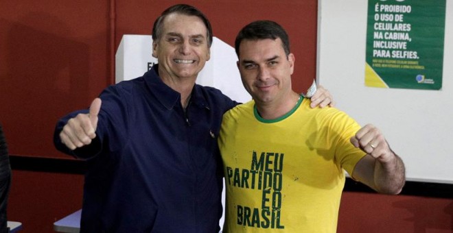 Jair Bolsonaro, y su hijo, Flávio, tras depositar su voto en las elecciones, Río de Janeiro, Brasil, 7 de octubre de 2018. / Ricardo Moraes / Reuters