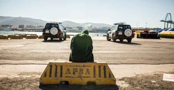 Un migrante descansa en el puerto de Algeciras, custodiado por la Guardia Civil tras ser rescatado por Salvamento Marítimo junto a potros migrantes a bordo de una patera.- JAIRO VARGAS