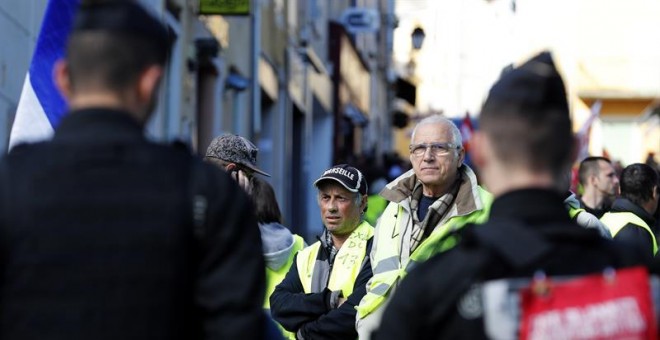 Policías franceses bloquean el paso de una protesta de los chalecos amarillos y de miembros del sindicato francés Confederación General del Trabajo (CGT), este jueves cerca del Centro de Congreso l'Etoile en Greoux Les Bains, Francia, donde tiene lugar el
