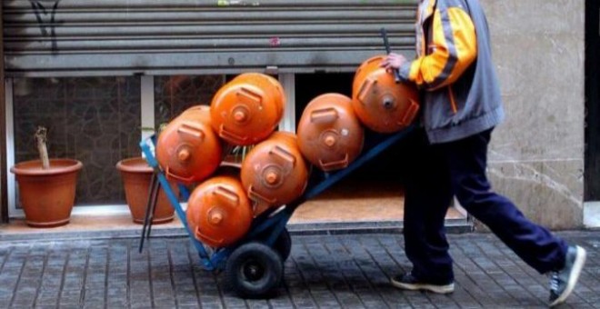 Un hombre carga seis bombonas de butano, en una imagen de archivo / EFE