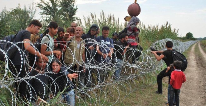Varios refugiados sirios intentan saltar la alambrada de la frontera entre Hungría y Serbia en Röszke. | EFE