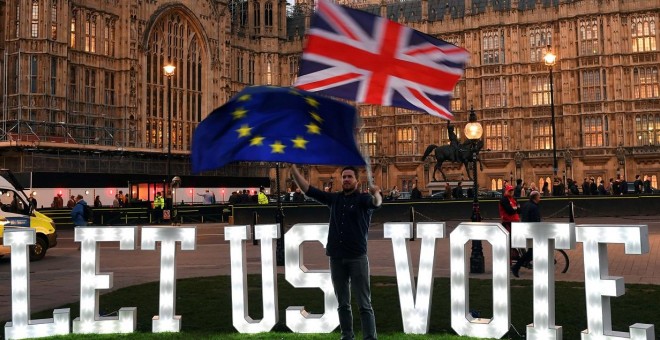 Un manifestante anti-Brexit ondea banderas frente a las Casas del Parlamento en Londres, | Reuters