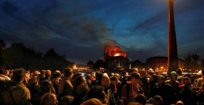 Miles de persona contemplan el incendio de Notre Dame en París. (IAN LANGSDON | EFE)