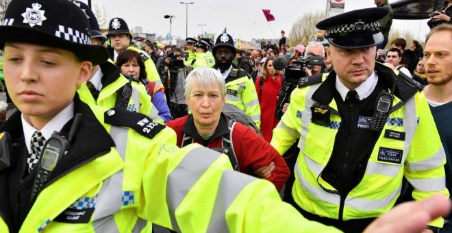 16/04/2019 - Agentes de policía se llevan a una activista para desbloquear del puente de Waterloo en el segundo día de protestas | AFP/ Daniel Leal-Olivas