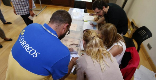 Un funcionario de Correos entrega en una mesa electoral los votos por correo. EFE