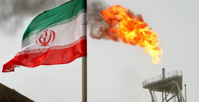 Un bandera de Irán cerca de una llamarada de gas en una plataforma de producción de petróleo en los campos petrolíferos de Soroush, en el Golfo Pérsico. REUTERS / Raheb Homavandi