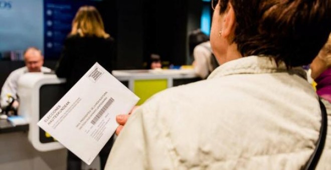 Una mujer hace cola en una oficina de correos para depositar su voto. | EFE