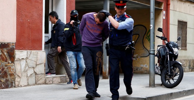 07/05/2019.- Un Mosso d'Esquadra custodia a uno de los dos detenidos en Cornellà de Llobregat (Barcelona) por su supuesta relación con la desaparición de Janet Jumillas. / EFE - ENRIC FONTCUBERTA