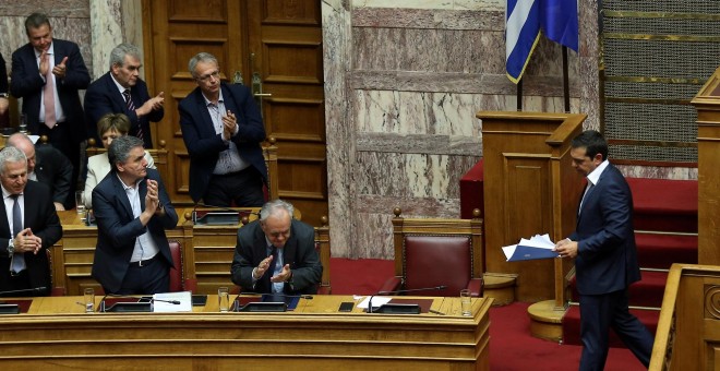 El primer ministro griego, Alexis Tsipras, recibe un aplauso de los ministros de su gobierno tras un discurso durante una sesión parlamentaria. | Reuters