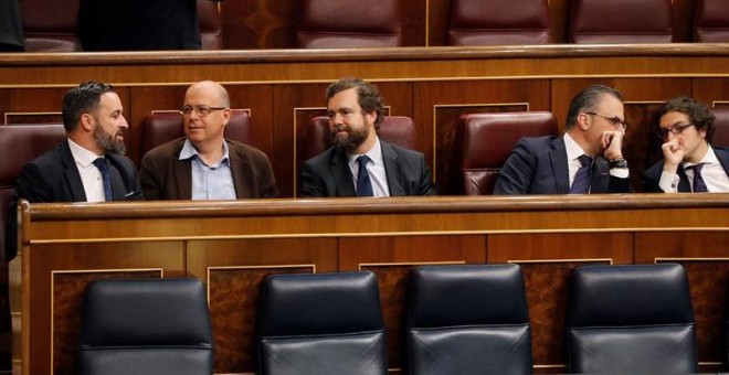 El presidente de VOX, Santiago Abascal, conversa con el diputado del PSC José Zaragoza en los escaños del Congreso de los Diputados. - EFE