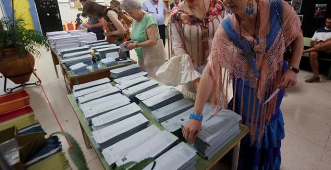 26/05/2019.- Dos mujeres vestidas de flamenca eligen sus papeletas en un colegio de Córdoba donde se está celebrado la Feria de Nuestra Señora de la Salud, hoy 26 de mayo en el que un total de 6,64 millones de electores andaluces podrán ejercer su derecho