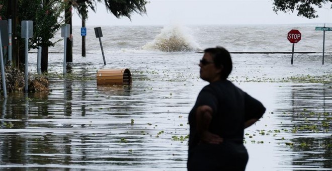 Una mujer contempla una calle inundada cerca del lago Pontchartrain, en Mandeville. EFE/EPA/DAN ANDERSON