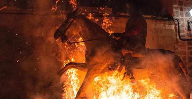 Un caballo, obligado a trotar sobre el fuego en la celebración de la Luminarias de San Bartolomé, en Ávila