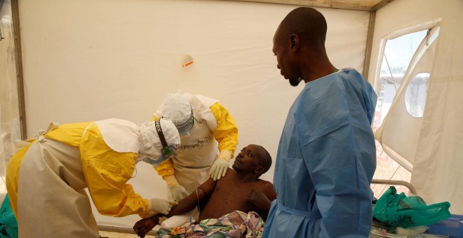 Profesionales médicos y un superviviente de ébola tratan a un paciente dentro de las instalaciones en Beni. / Reuters