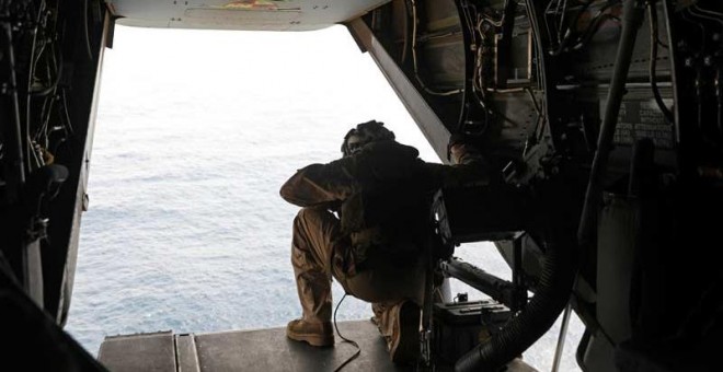 Un marine estadounidense mira desde un avión que vigila las aguas del Golfo de Omán. (AHMED JADALLAH | REUTERS)