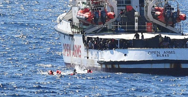 Varios migrantes saltan por la borda del Open Arms para llegar a nado a la isla italiana de Lapedusa, desesperados tas 19 días encerrados en el barco español.- REUTERS